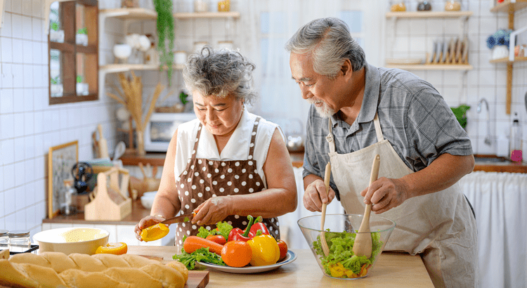 Retired couple making a meal in their new home after downsizing in Tallahassee, Florida real estate.